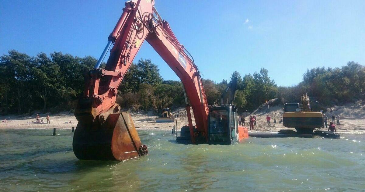 Расчистка валунов. Водяной экскаватор. Экскаватор на воде. Экскаватор у моря. Перевернутый экскаватор в воде.