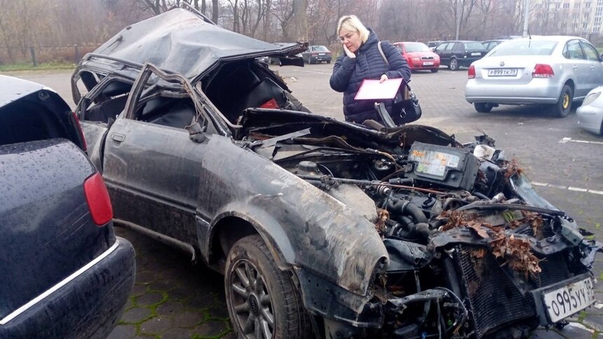 На фото: Юлия около остатков машины, в которой погибли Павел Коваленко и Андрей Галушка | Фото: Юлия Коваленко