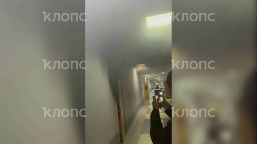 Учащиеся снимают клубы чёрного дыма, вырывающиеся из-за двери  | Скриншот видеозаписи 