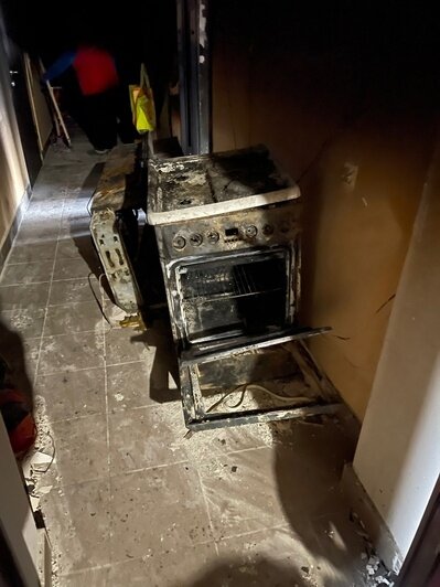 Из квартиры, где произошёл пожар вытаскивают сгоревшие вещи | Фото: Виктория 