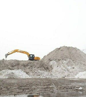 Выросла гора: коммунальщикам пришлось загнать экскаватор на вершину главной снегосвалки Калининграда (фото)